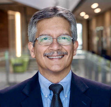"smiling Hispanic gentleman with mustache wearing glasses"