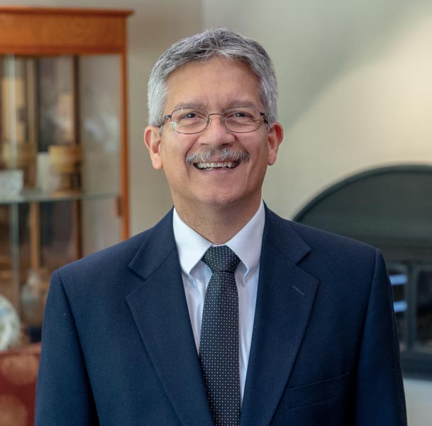 "smiling Hispanic gentleman with mustache wearing glasses"